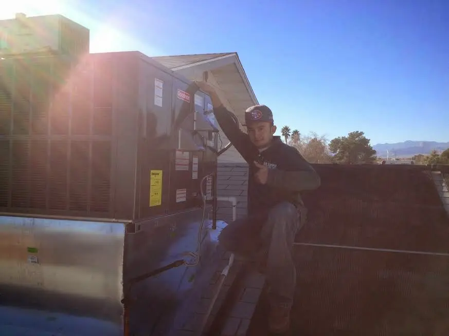 HVAC technician performing HVAC Inspection on a rooftop unit in Evesham